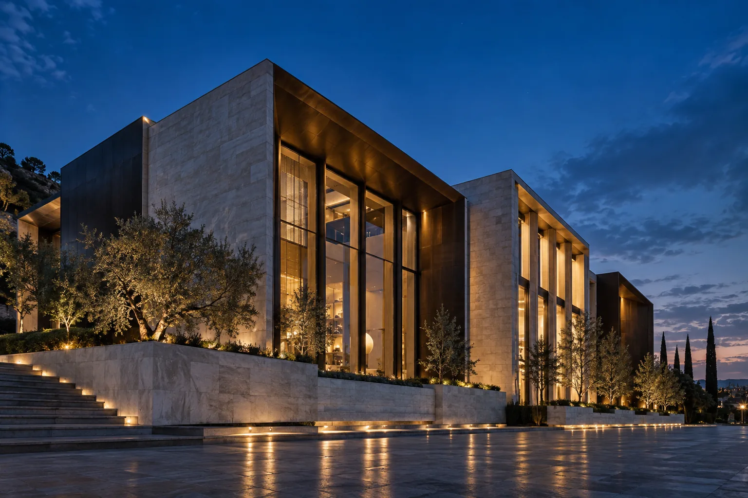 Warmly lit bronze and stone facade beneath a deep blue evening sky